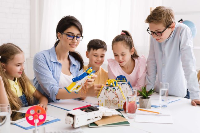 school-children-constructing-robots-with-teacher-i-4RQZU9D (1)_11zon how-you-can-work-as-a-teacher-in-Arkansas